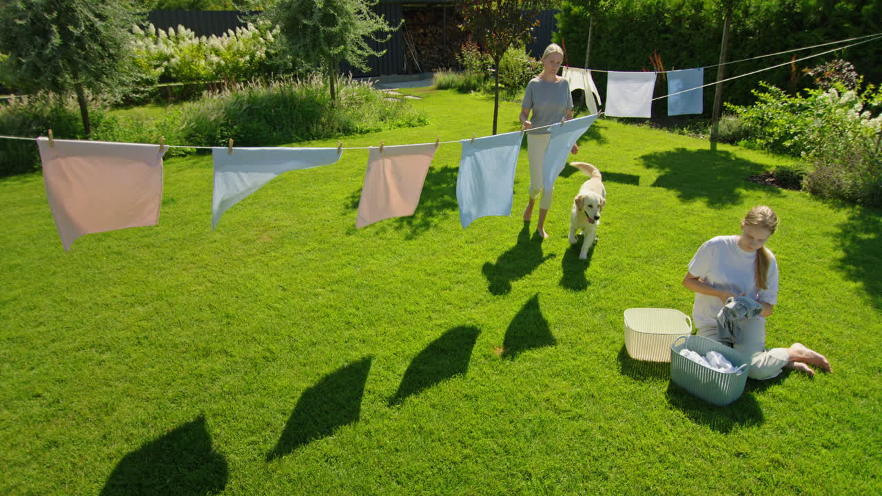 어머니와 딸이 밖에서 세탁을 하고 있습니다.