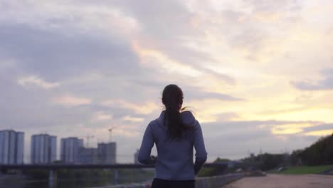 Mujer-Deportiva-Con-Capucha-Revisando-Su-Reloj-Inteligente-Y-Tomando-Un-Descanso-Después-De-Su-Sesión-De-Carrera