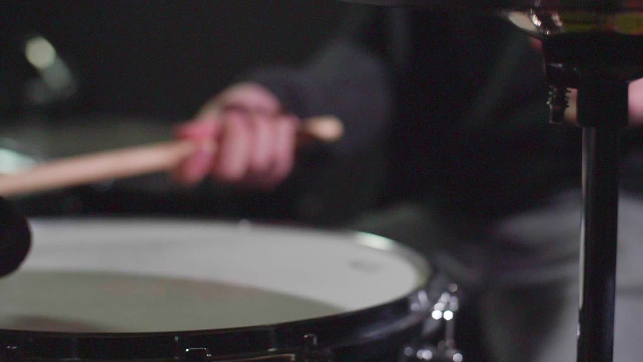 Smooth close up of a shiny drum Hi-Hat cymbal and a snare being played with sticks. with stick landing on snare in close up. Gimbal forward movement. Shallow depth with fixed focus. Shot in 4K
