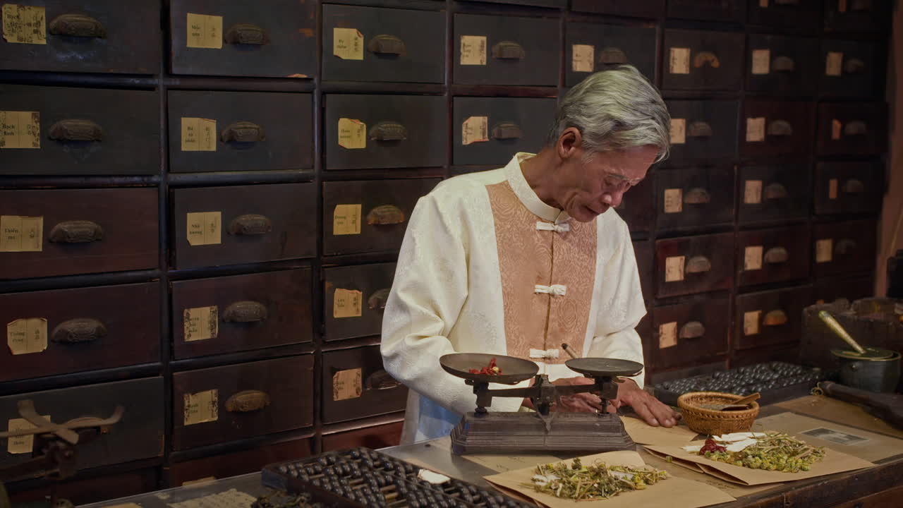 Senior Herbalist Putting Dried Ingredients on Scales at Apothecary