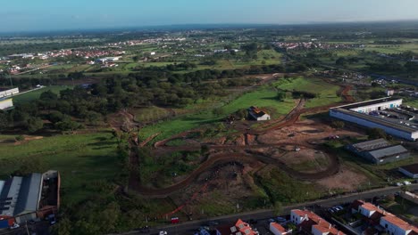 rotate drone shot of muddy dirt rally track in the town