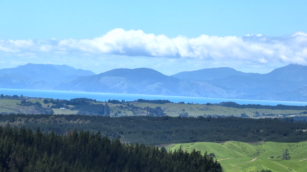 멀리 태즈만 만과 넬슨의 드론, 전면에 초록색 풍경, 뉴질랜드