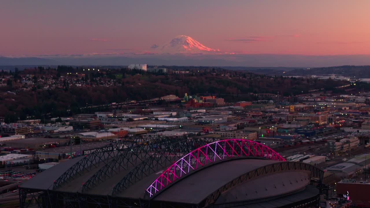 Drone shot of Mount Rainier at sunset with Seattle's baseball stadium in the foreground