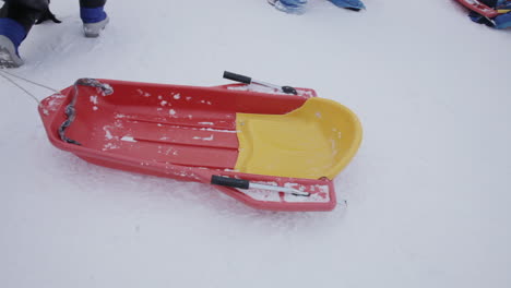 a person dragging a snowsled across freshly fallen snow, reveling in the delights of a winter day filled with fun, sports and games