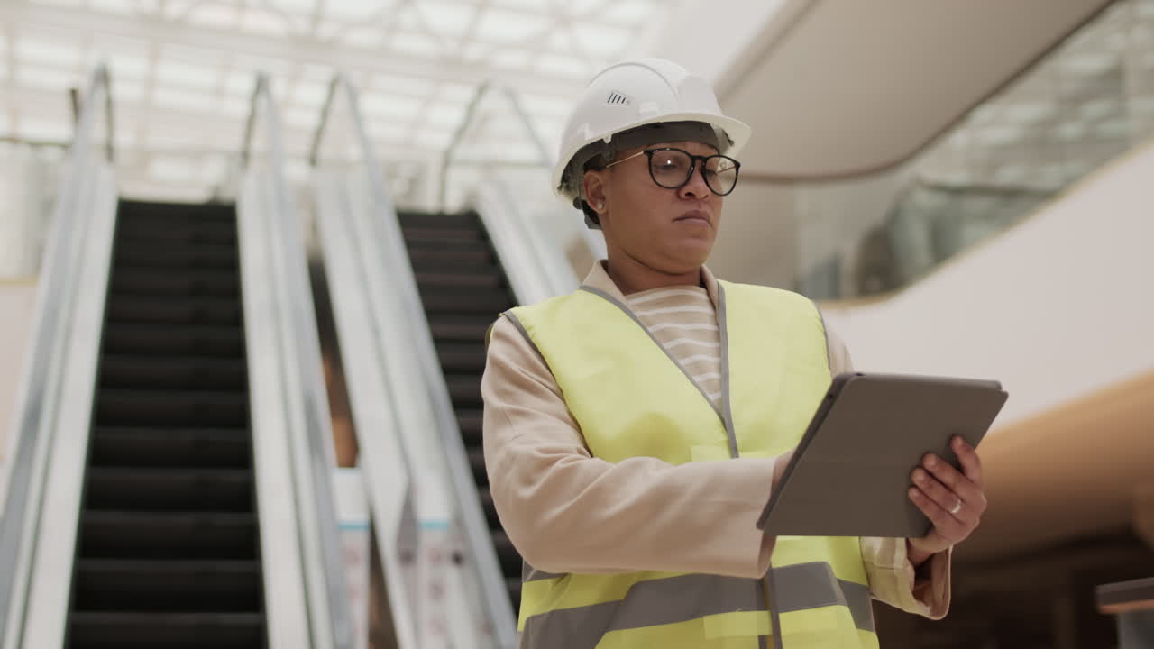 trabajador de la construcción usando una tableta en el centro comercial