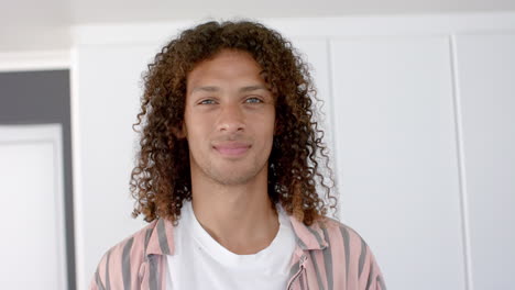 joven biracial sonríe con confianza en casa