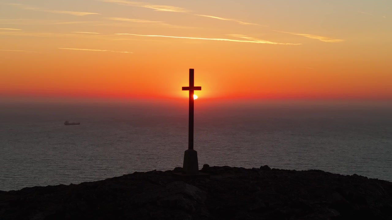 Il sole sorge sull'oceano, stagliando una croce su una collina a Bray. Ideale per temi spirituali o contenuti di viaggio.