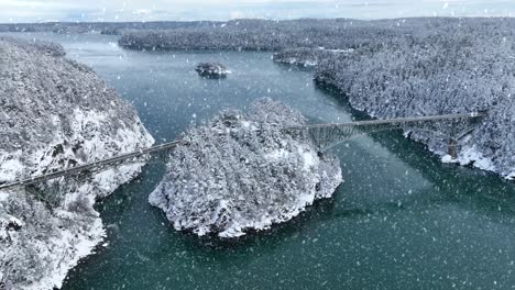 disparo de dron del paso de engaño que conecta fidalgo y whidbey island con nieve cayendo activamente