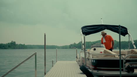 Bearded-man-walks-on-a-dock-and-onto-a-boat