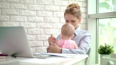 business woman embracing little girl in home office