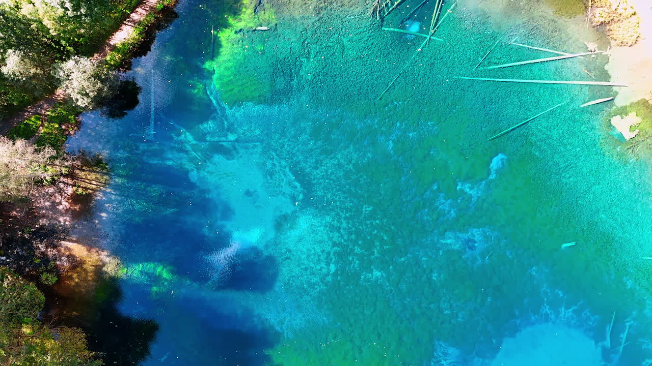 Going up over the crystal clear azure lake Christlessee in the Bavarian Alps. Some tourists walk around the picturesque lake.