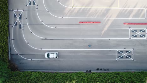 Vista-Aérea-Del-Conductor-Del-Automóvil-Durante-La-Prueba-De-Giro-En-L-Entre-Conos.