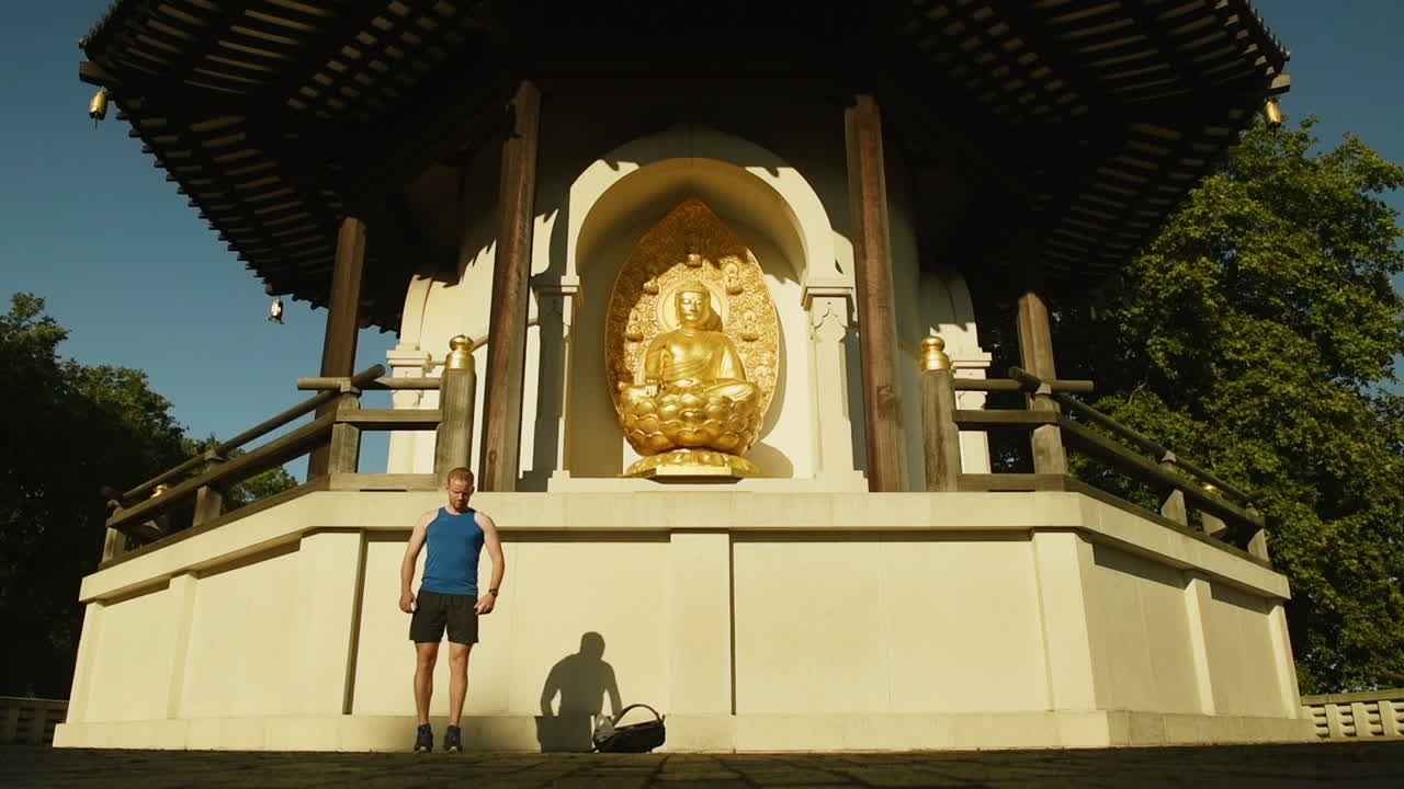 Male runner stretching his legs in front of the Peace Pagoda at Battersea Park