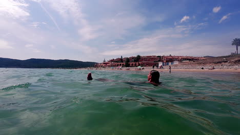 close up shot of a young woman floating on water surface in crystal clear turquoise sea during a trip on a sunny day