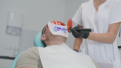 procedimiento de blanqueo de dientes. gel blanqueador de dientes. el dentista hace el procedimiento de blankeo