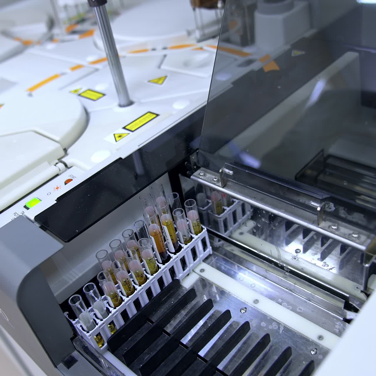 Test tubes filled with blood are placed into the apparatus. Medical vials are moving in the equipment at science hospital laboratory