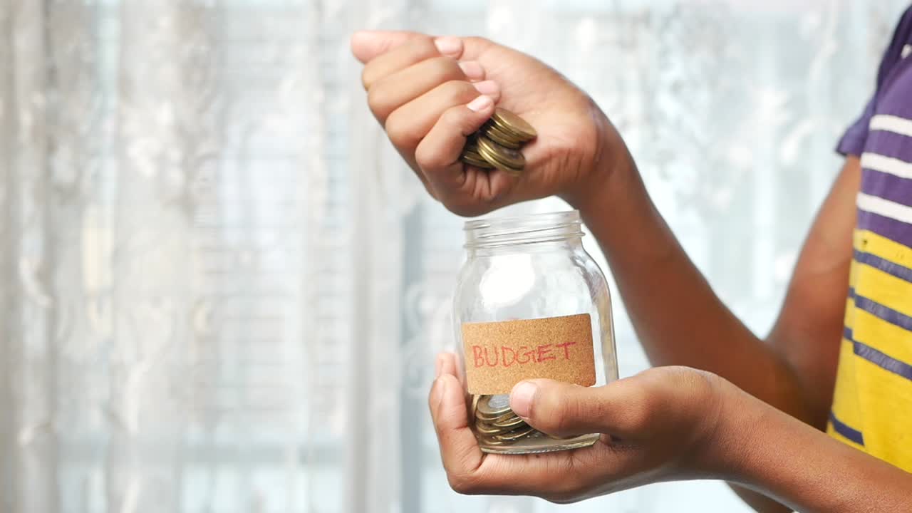 Child Saving Money in a Jar