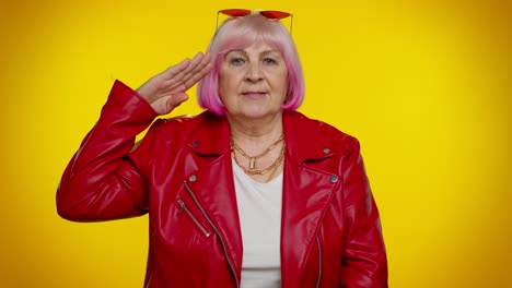 mature old grandmother giving salute listening to order as if soldier, following discipline, obeying