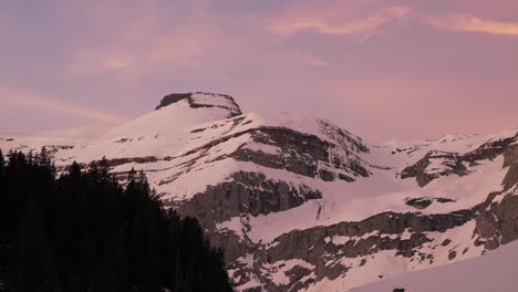 witness the beauty of sunrise over a snowy mountain range through this mesmerizing pink clouds