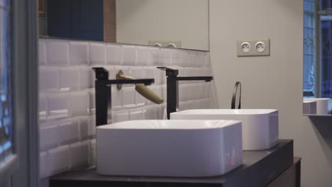 slow revealing shot of a double vanity unit within a bathroom with a large mirror