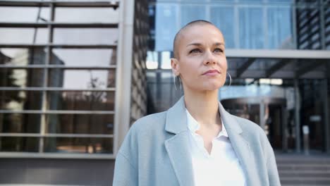 confident business woman looking away while standing outdoors on the street at the financial city district.