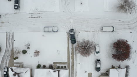 Pick-up-truck-backs-out-of-a-driveway-onto-a-snowy-road