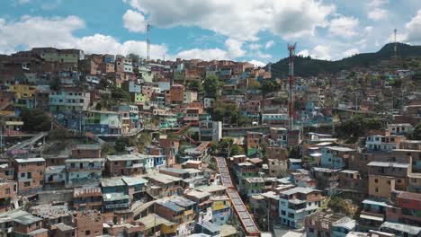 drone aerial landscape view of comuna 13 slums touristic neighborhood, flying towards famous escalators in medellin, colombia