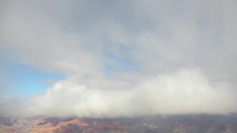 slow pan and tilt down from the clouds to the grand canyon