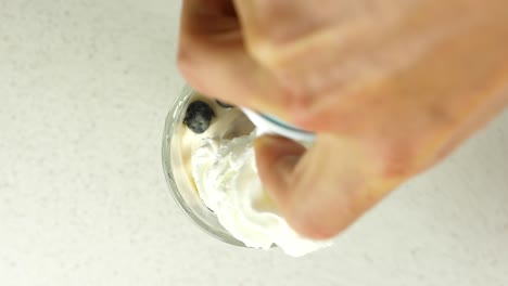 topping a dessert with canned cream and a fresh strawberry