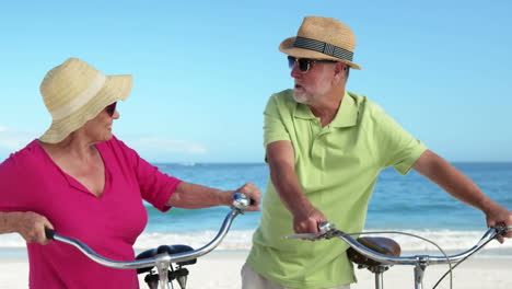 animación de hacerlo por ellos más feliz caucásica pareja de ancianos con bicicletas en la playa