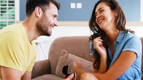 Man-offering-a-engagement-ring-to-woman-in-the-living-room