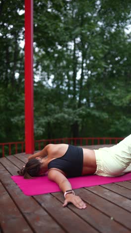 Woman doing yoga outdoors on a wooden deck