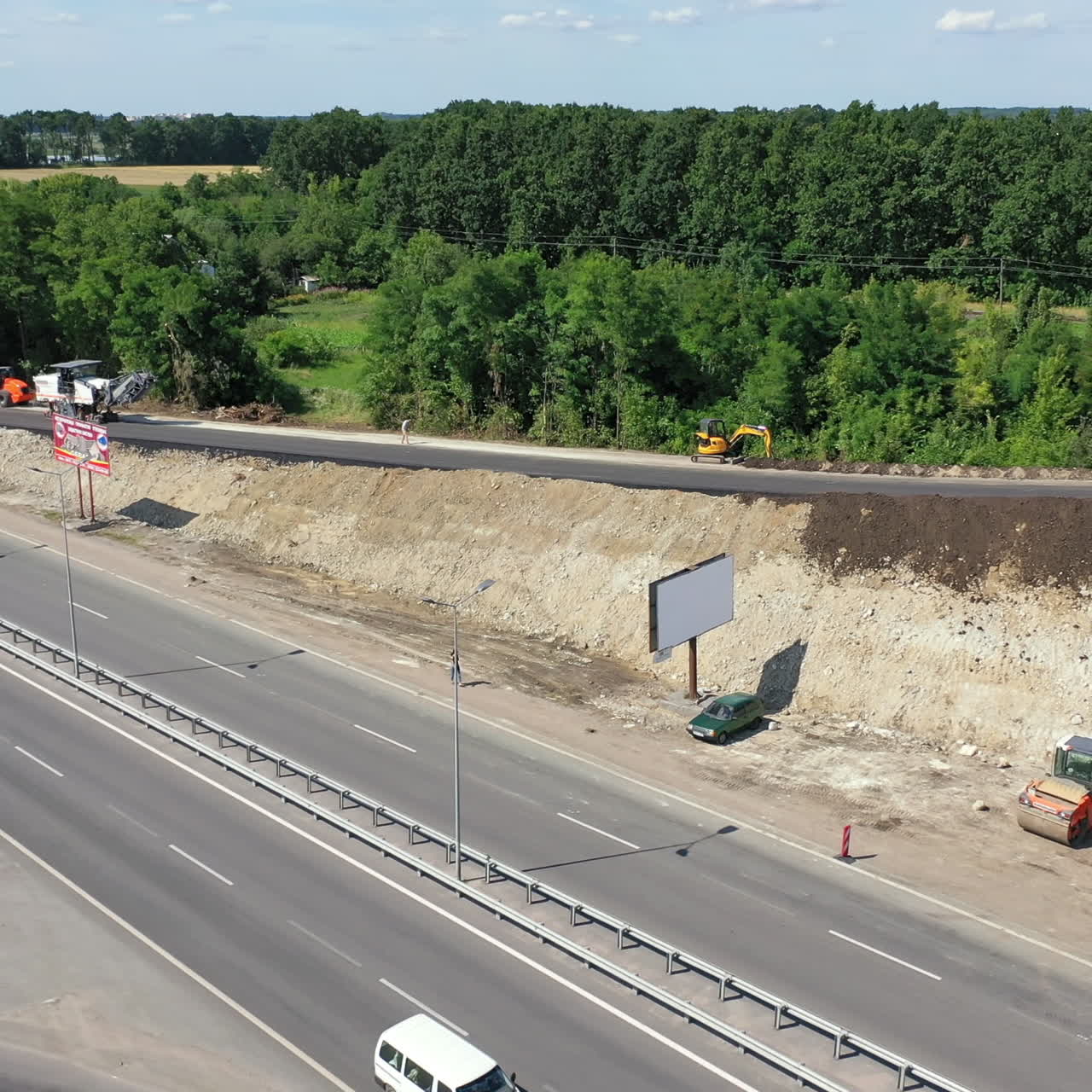 Cars and trucks on the highway. New road construction. Heavy machinery laying new asphalt road. Unfinished road near the highway in a sunny summer day. Top view.
