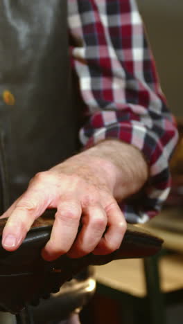 shoemaker hammering on a shoe in workshop