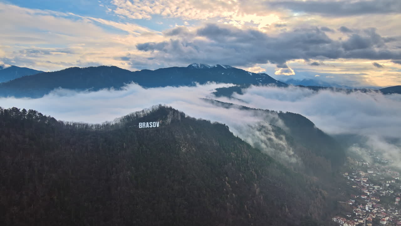 Brasov sign on the top of the hill near the city, bare trees, low clouds, Romania