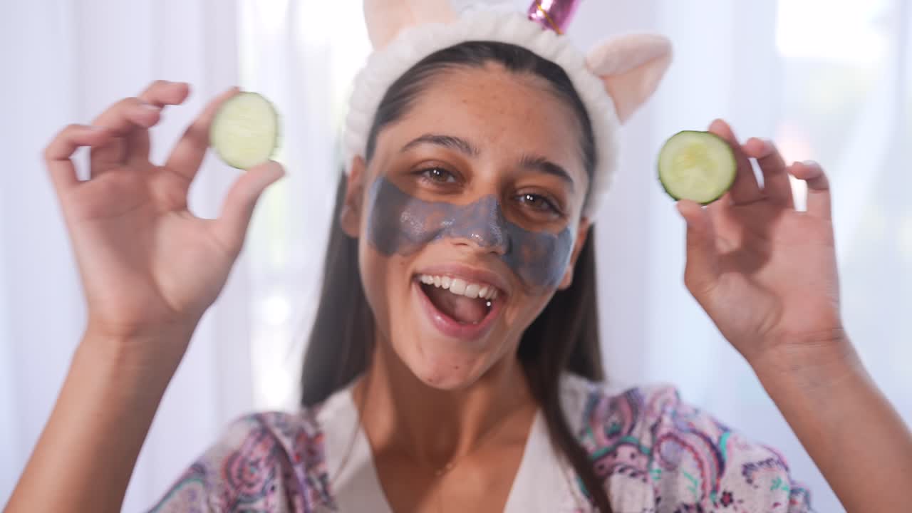 mujer divirtiéndose con máscara de pepino y cinta de unicornio