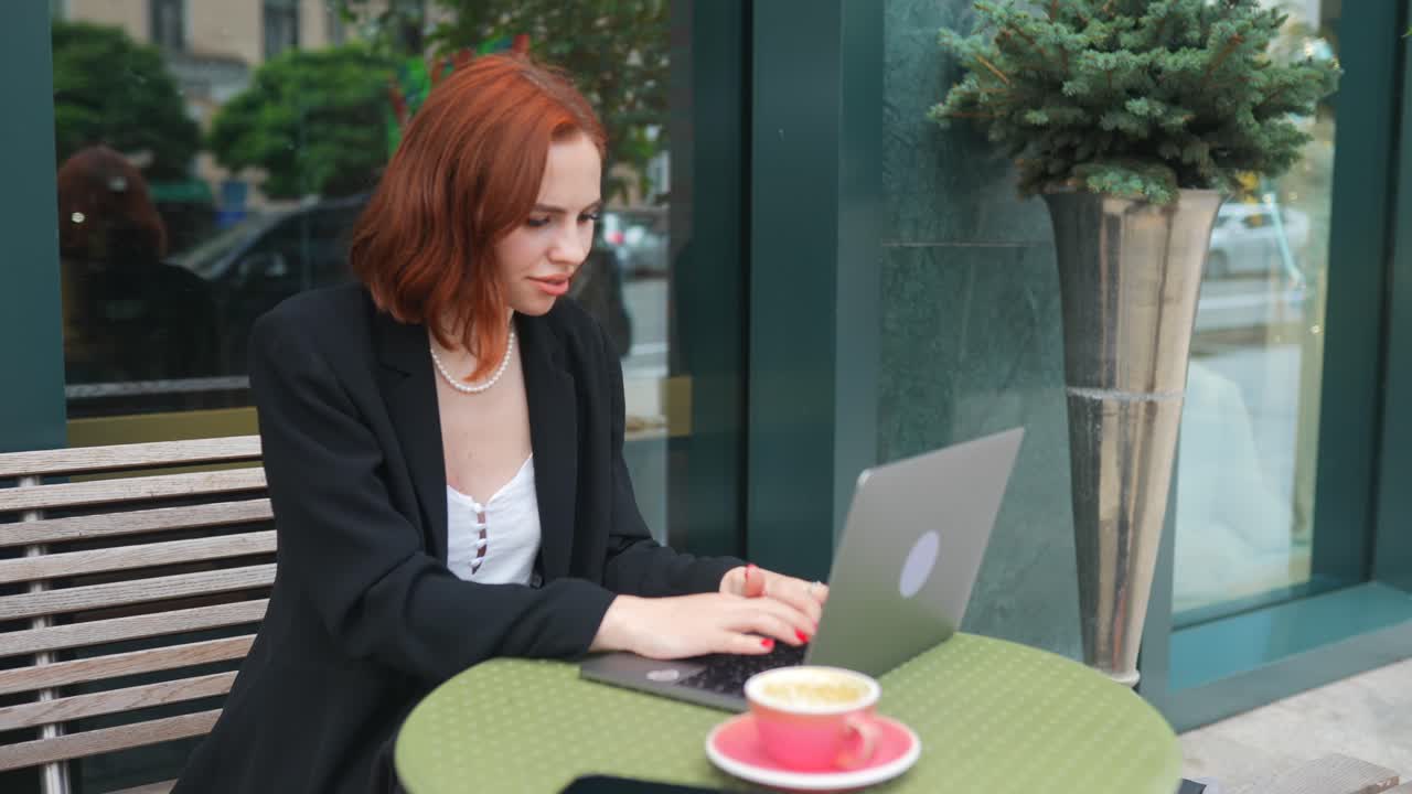 Donna che lavora al computer portatile in un caffè