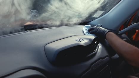 hombre desinfectando el salpicadero del coche con vapor