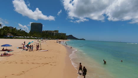 flying over waikiki beach, slow motion fpv drone over turquoise blue waters in oahu with beachgoers enjoying the sunshine