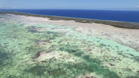 Aerial-pan-over-the-vibrant-southern-barrier-of-Los-Roques,-showing-crystal-waters-and-coral-reefs,-daylight