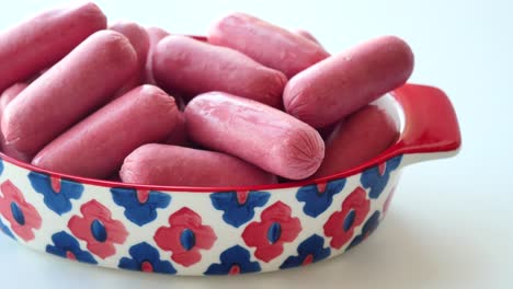 Miniwurst-In-Einer-Roten-Schüssel-Auf-Weiß