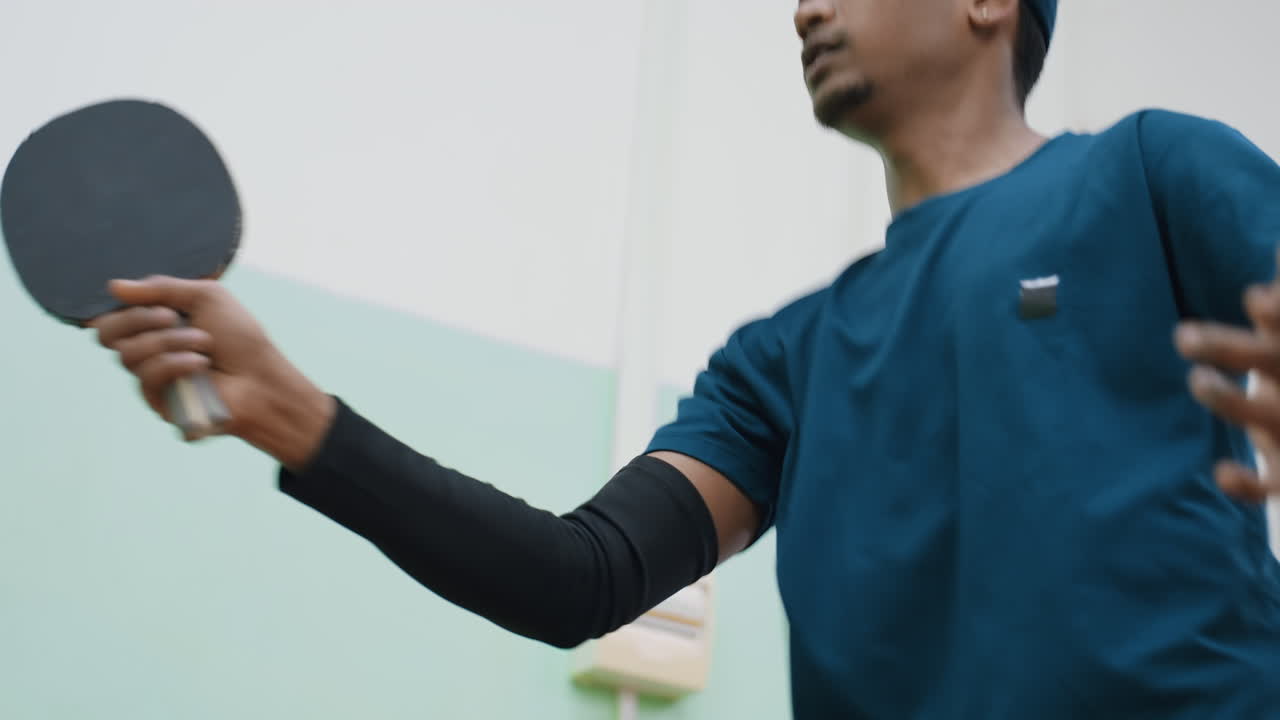 Close up of athlete in sportswear training indoors with intense focus, blur view of socket in background, highlighting determination, energy, and movement during physical practice session