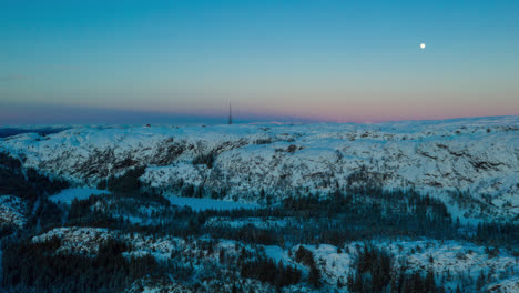 Beautiful-aerial-hyperlapse-showing-the-golden-hour-turn-into-blue-hour-right-after-sunset-over-snowy-mountains