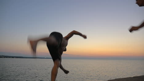 Two-young-guys-doing-tricks-jumping-from-pier