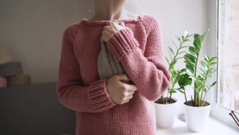 manos femeninas sosteniendo ropa de punto para el bebé. madre esperando al bebé