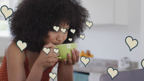 animation of social media heart icons over biracial woman drinking coffee