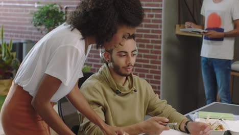 Joven-Líder-De-Equipo-De-Mujer-De-Negocios-Negra-Que-Muestra-La-Investigación-Del-Proyecto-De-Un-Colega-En-La-Pantalla-De-Una-Computadora-Portátil-Compartiendo-Ideas-Creativas-En-Diversos-Lugares-De-Trabajo-De-Oficina