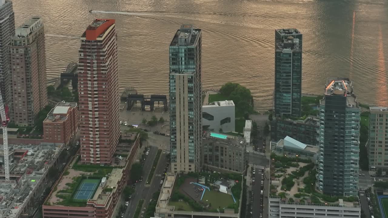 Drone view of New York City skyscrapers by the river at sunset