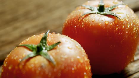 Water-droplets-on-red-tomatoes-placed-on-wooden-surface-4K-4k