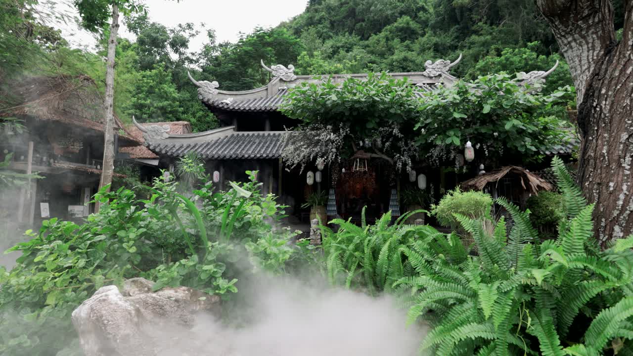 Sương mù bốc lên trên ngôi đền mái ngói truyền thống màu sẫm nép mình giữa cây xanh nhiệt đới tươi tốt và dương xỉ tại Ngũ Hành Sơn.